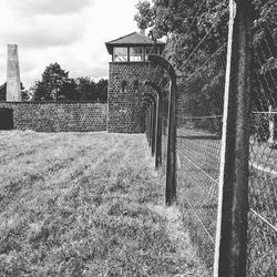 Fence and trees on field against sky