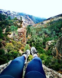 Low section of person on rock in mountains