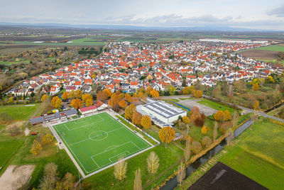 Community soccer field surrounded by residential area and rural landscape in autumn