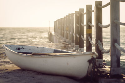 Boat moored on beach against clear sky