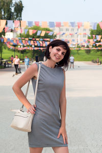 Portrait of young woman standing on road