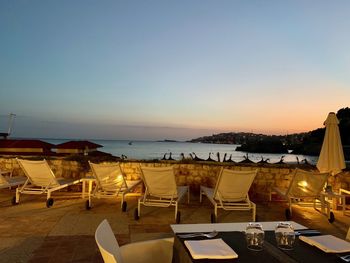 Scenic view of beach against clear sky at sunset