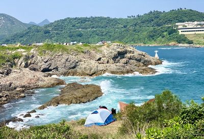 Man sitting on rock by sea