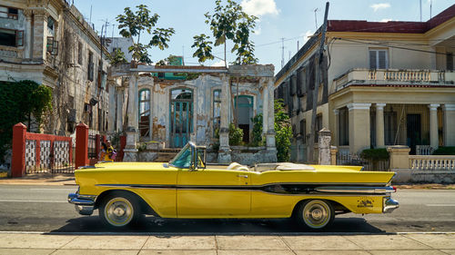 Car on street against buildings in city