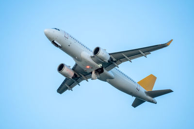 Low angle view of airplane flying against clear sky