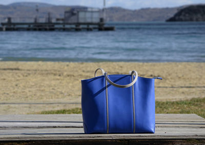 Close-up of deck chairs on beach against sea