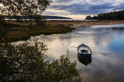 Boat moored on river against sky