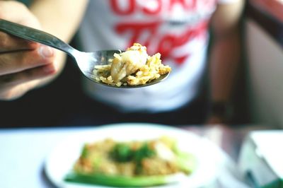 Midsection of person holding food in spoon