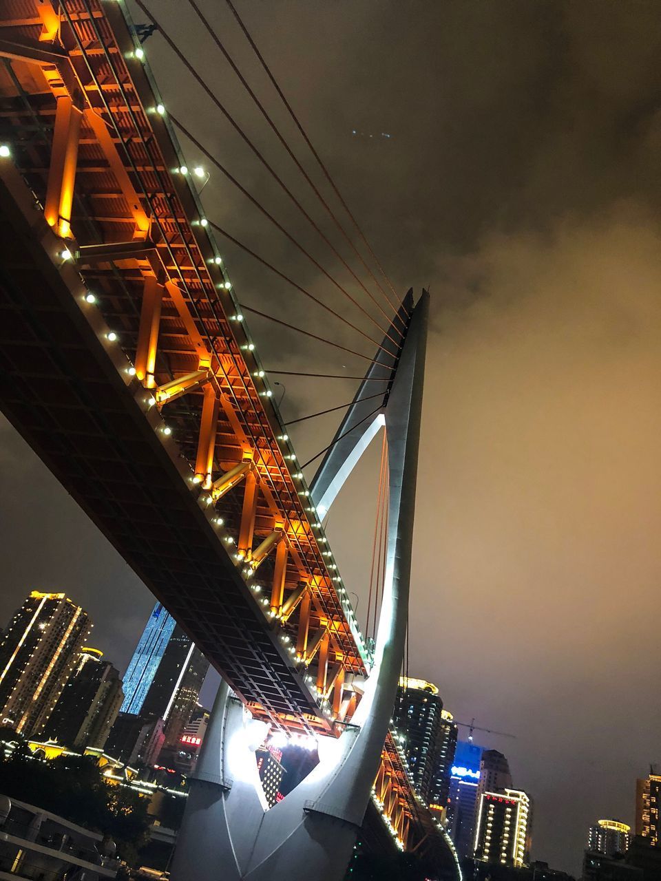 LOW ANGLE VIEW OF ILLUMINATED SUSPENSION BRIDGE