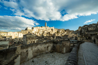 Buildings in city against cloudy sky