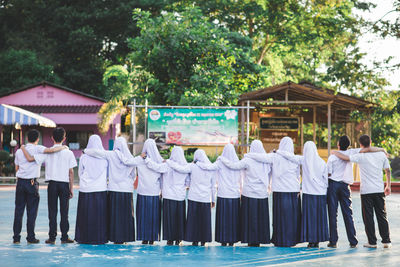 Rear view of people standing outside house