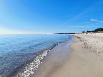 Scenic view of beach against blue sky