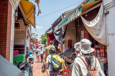 Rear view of people walking on street in city