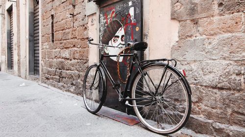 Bicycle leaning against brick wall