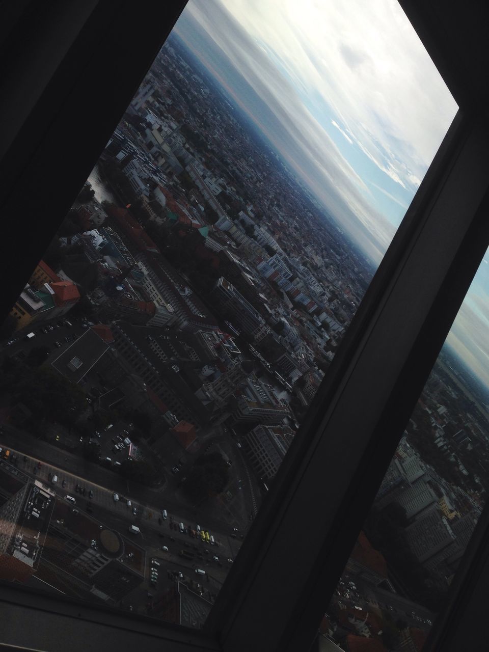 window, aerial view, airplane, city, built structure, vehicle interior, no people, indoors, air vehicle, close-up, cityscape, day, sky, architecture, airplane wing