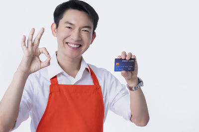 Portrait of smiling man standing against white background