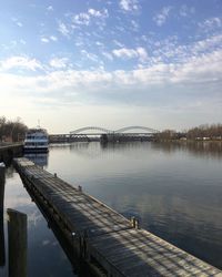 Bridge over river against cloudy sky