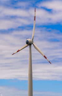 Wind power turbines generating against cloudy sky