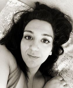 Portrait of young woman lying down on bed