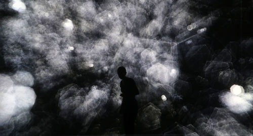 Rear view of silhouette man standing at night