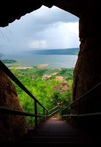 Scenic view of landscape against sky seen through railing