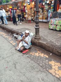 People sitting on street at market