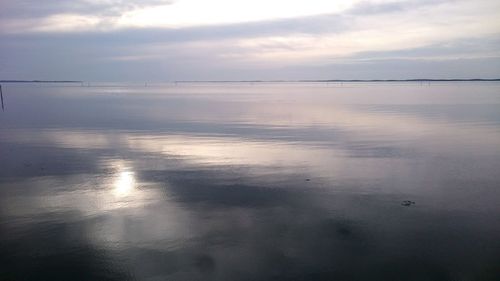 Reflection of clouds in sea at sunset