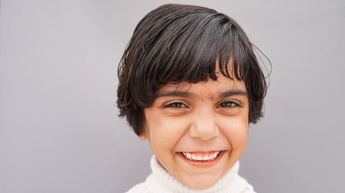 Image of asian child posing face expression on gray background. attractive little child with short b