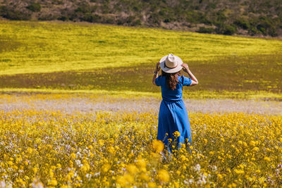 Rear view of woman standing on field