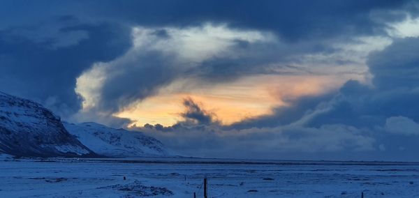 Scenic view of smow covered lava field against sky during winter