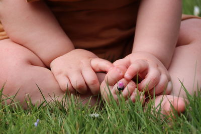 Midsection of little child/baby holding grass