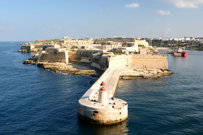 Ship in sea against buildings in city