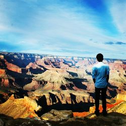 Rear view of man looking at mountain against sky