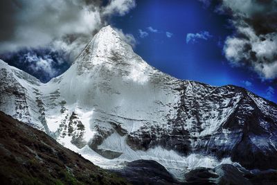 Scenic view of snowcapped mountains against cloudy sky