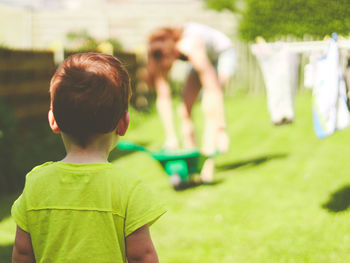 Rear view of boy standing in yard 