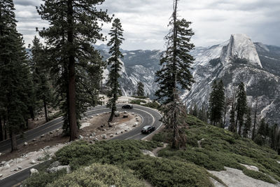 High angle view of winding road in forest against mountains