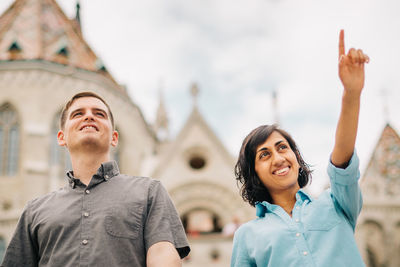 Couple holding hands while standing against church