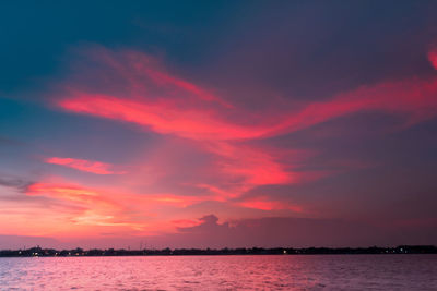 Scenic view of sea against dramatic sky during sunset