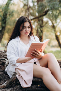 Young woman sitting on book