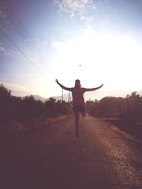 Rear view of man standing on road against sky