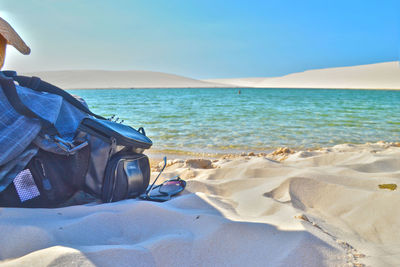 Low section of man relaxing on beach