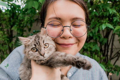 Young asian woman playing with her persian cat, human-animal relationships.