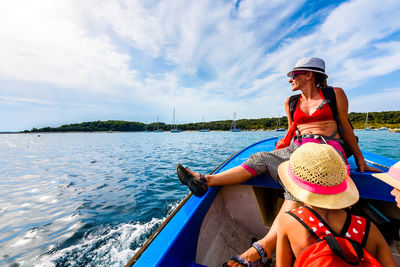 Friends in boat on river against sky