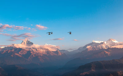 Scenic view of snowcapped mountains against clear blue sky