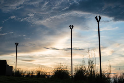 Low angle view of street lights against sky during sunset