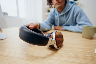 Midsection of man holding headphones