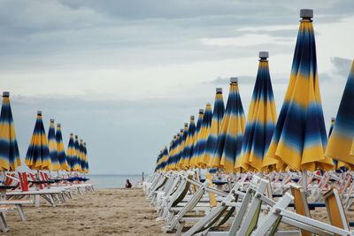 Panoramic view of chairs on beach against sky