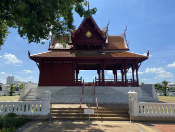 Temple by building against sky