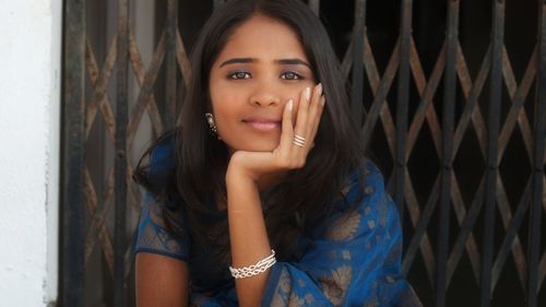 Portrait of beautiful woman standing against wall