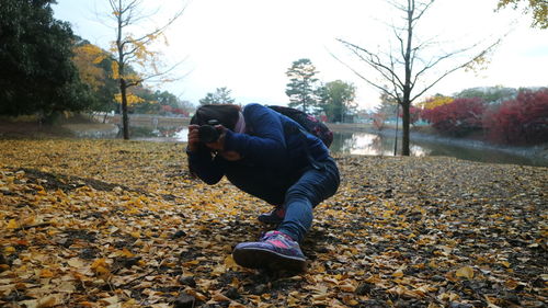 Man photographing with autumn leaves in winter